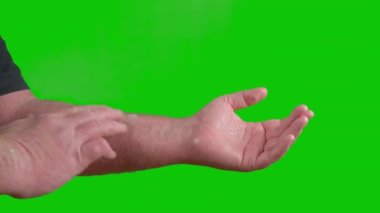 Hand of a man covered with psoriasis ointment on a green screen. High quality 4k footage