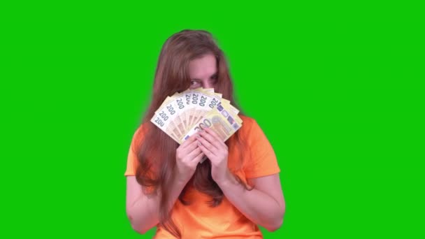 Young Woman Orange Shirt Money Looks Camera Green Screen High — 图库视频影像