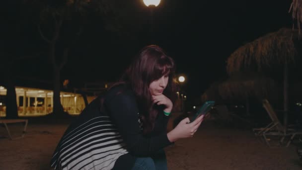 Ung Kvinna Bläddra Igenom Telefon Bakgrund Beach Night Högkvalitativ Film — Stockvideo