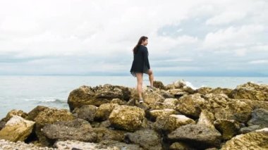 Genç Kadın Kayalıklarda Duruyor ve Korfu Yunanistan 'ı inceliyor. Yüksek kalite 4k görüntü