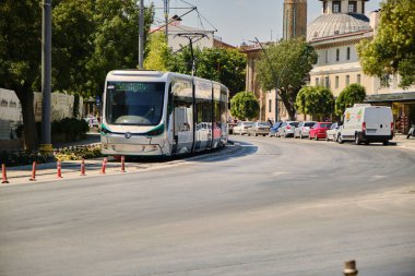 22.07.2021. Konya. Hindi. Konya şehir merkezinde ulaşım tramvayı ve ince minareli camii, yerel adı cami arkaplan