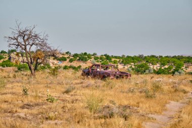 Terk edilmiş araba, Brownfield tarafında ve kirli yolda parçalanmış araba.