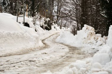Yollar karla kaplı, yolda kamyon izleri var. Kış mevsiminde buzlu yol