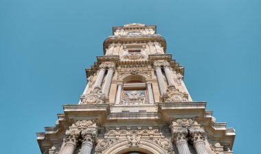 Düşük açılı fotoğraf. Dolmabahce saat kulesinin alçak açılı fotoğrafı ve mavi gökyüzü arkaplanı. Osmanlı mimarisinin sanat eseri, barok tarzı.