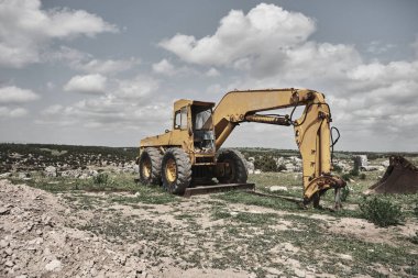Terk edilmiş ve kahverengi alan kazıcı, dağın zirvesinde not veren, terk edilmiş inşaat makinesi..
