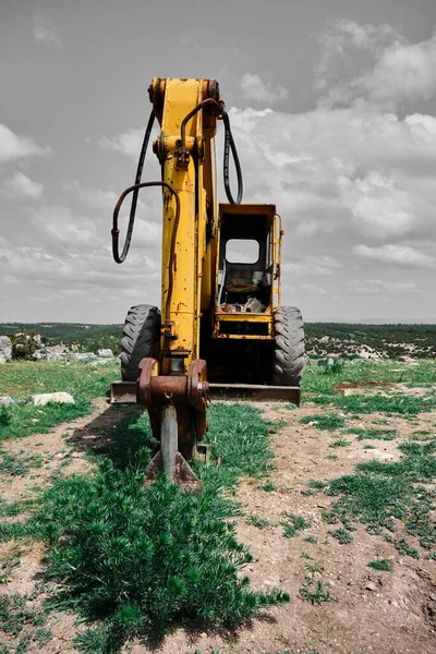 Terk edilmiş ve kahverengi alan derecelendiricisinin düşük açılı görüntüsü, dağın zirvesinde not veren, terk edilmiş inşaat makinesi.