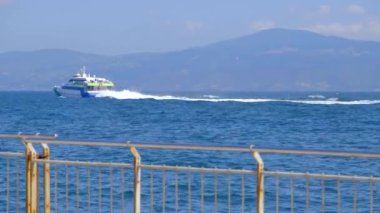 4k Video, Marmara Denizi 'nde büyük bir gemi, yolcu nakliye gemisi, dalgalı denizde ve büyük dağ ve ufuk arkaplanında ilerliyor..