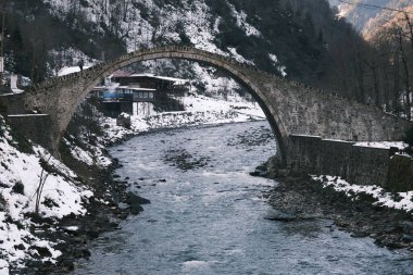 Stone made bridge at winter, snow covers the bridge at winter. Bridge and firtina river flow