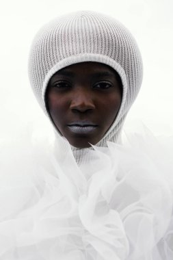 Uzaylı. Beyaz tül fırfırlar içinde mükemmel bir vücudu olan Afrikalı güzel bir model. Çikolata tenli. Minimalist bir geçmiş. Sakin ve dengeli