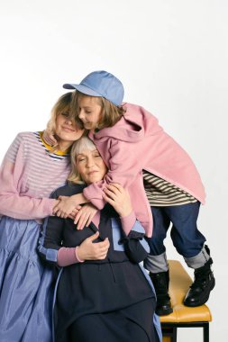 Mutlu aile fotoğrafı. Üç güzel kadın model. Anne, kız ve büyükanne. Farklı nesiller. Kadınlar Günü. Anneler Günü. Çocukluk. Aşk hakkında. Renkli ve rahat. Şık kıyafetler.. 