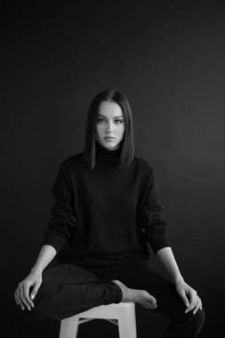Genç fantastik modelin siyah beyaz fotoğrafı. Avrupalı bir tip, harika dudaklar, güzel gözler. Siyah arka plan. Duygusal bir portre. Minimalist ve şık. Moda. Kozmetik reklamı için iyi..