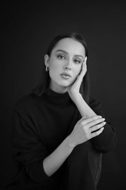 Genç fantastik modelin siyah beyaz fotoğrafı. Avrupalı bir tip, harika dudaklar, güzel gözler. Siyah arka plan. Duygusal bir portre. Minimalist ve şık. Moda. Kozmetik reklamı için iyi..