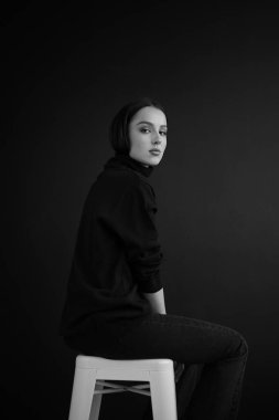 Genç fantastik modelin siyah beyaz fotoğrafı. Avrupalı bir tip, harika dudaklar, güzel gözler. Siyah arka plan. Duygusal bir portre. Minimalist ve şık. Moda. Kozmetik reklamı için iyi..