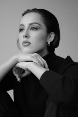 Genç fantastik modelin siyah beyaz fotoğrafı. Stüdyo. Avrupalı bir tip, yakışıklı dudaklar, güzel gözler. Beyaz arka plan. Duygusallık. Minimalist ve şık. Moda. Kozmetik reklamı için iyi..