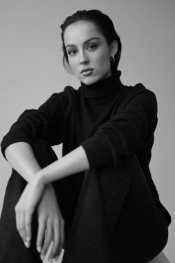 Genç fantastik modelin siyah beyaz fotoğrafı. Stüdyo. Avrupalı bir tip, yakışıklı dudaklar, güzel gözler. Beyaz arka plan. Duygusallık. Minimalist ve şık. Moda. Kozmetik reklamı için iyi..