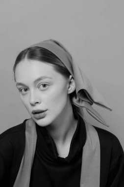 Sarışın güzel bir kızın portresi. Avrupalı. Bebek yüzlü. Siyah beyaz fotoğraf. Yumuşak ışık. Temiz ten, güzel büyük gözler ve dudaklar. İyi kalite. Modaya uygun retro görünüm. Duygular. Gençlik sorunları.