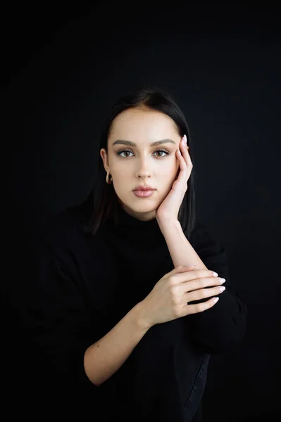 Genç fantastik modelin zarif fotoğrafları. Stüdyo. Avrupalı bir tip, yakışıklı dudaklar, güzel gözler. Siyah arka plan. Siyah kıyafetler. Duygusallık. Minimalizm. Çok şık. Kozmetik reklamı için iyi.