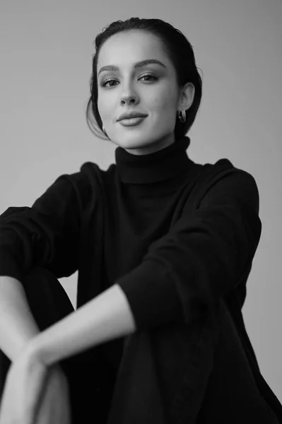 Genç fantastik modelin siyah beyaz fotoğrafı. Stüdyo. Avrupalı bir tip, yakışıklı dudaklar, güzel gözler. Beyaz arka plan. Duygusallık. Minimalist ve şık. Moda. Kozmetik reklamı için iyi..