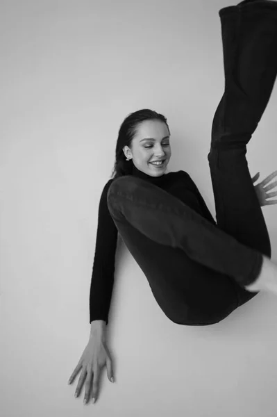 Genç fantastik modelin siyah beyaz fotoğrafı. Stüdyo. Avrupalı bir tip, yakışıklı dudaklar, güzel gözler. Beyaz arka plan. Duygusallık. Minimalist ve şık. Moda. Kozmetik reklamı için iyi..