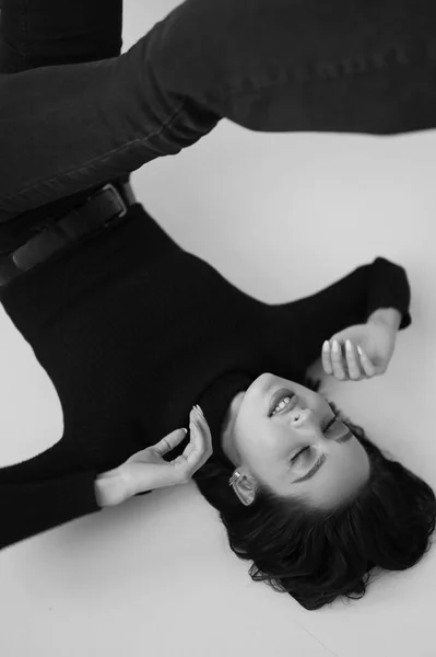Genç fantastik modelin siyah beyaz fotoğrafı. Stüdyo. Avrupalı bir tip, yakışıklı dudaklar, güzel gözler. Beyaz arka plan. Duygusallık. Minimalist ve şık. Moda. Kozmetik reklamı için iyi..