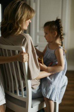 Mutfakta iki güzel kızı olan genç ve güzel bir anne. Mutlu aile kahvaltıları. Şık bir iç mekan. İyi ilişkiler. Komik çocuklar. Sevgi ve ilgi. Avrupalılar. Canlı ve doğal görüntü