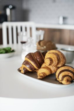 Beyaz masada lezzetli ve sağlıklı bir kahvaltı. Kruvasan, süt, bal, ekmek. Avrupa yaşam tarzı. Akdeniz yemekleri. Şık yemekler. Modern iç mekan. Taze fırın. Ispanak. Çay ve kahve. Taze meyve suyu