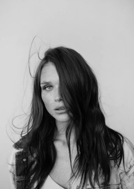 Uzun dalgalı saçlı güzel bir manken. Şehvetli ve çekici bir kadın. Çiller. Tarafsız bir arkaplan. Mükemmel kalite. Yumuşak ışık. Güzel kirpikleri, büyük dudakları, güzel gözleri var. Siyah beyaz portre. Reklamcılık
