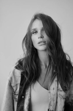 Uzun dalgalı saçlı güzel bir manken. Şehvetli ve çekici bir kadın. Çiller. Tarafsız bir arkaplan. Mükemmel kalite. Yumuşak ışık. Güzel kirpikleri, büyük dudakları, güzel gözleri var. Siyah beyaz portre. Reklamcılık