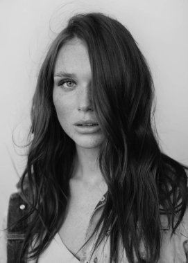 Uzun dalgalı saçlı güzel bir manken. Şehvetli ve çekici bir kadın. Çiller. Tarafsız bir arkaplan. Mükemmel kalite. Yumuşak ışık. Güzel kirpikleri, büyük dudakları, güzel gözleri var. Siyah beyaz portre. Reklamcılık