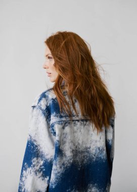 Kızıl saçlı, mavi gözlü ve uzun dalgalı kızıl saçlı güzel bir manken. Şehvetli ve çekici bir kadın. Çiller. Tarafsız bir arkaplan. Mükemmel kalite. Yumuşak ışık. Kot ceket. Güzel kirpikleri, büyük dudakları, güzel gözleri var.