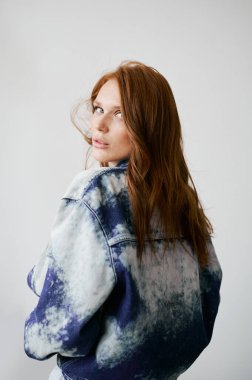 Kızıl saçlı, mavi gözlü ve uzun dalgalı kızıl saçlı güzel bir manken. Şehvetli ve çekici bir kadın. Çiller. Tarafsız bir arkaplan. Mükemmel kalite. Yumuşak ışık. Kot ceket. Güzel kirpikleri, büyük dudakları, güzel gözleri var.