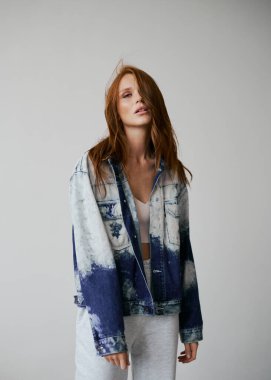 Kızıl saçlı, mavi gözlü ve uzun dalgalı kızıl saçlı güzel bir manken. Şehvetli ve çekici bir kadın. Çiller. Tarafsız bir arkaplan. Mükemmel kalite. Yumuşak ışık. Kot ceket. Güzel kirpikleri, büyük dudakları, güzel gözleri var.