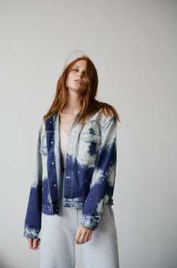 Kızıl saçlı, mavi gözlü ve uzun dalgalı kızıl saçlı güzel bir manken. Şehvetli ve çekici bir kadın. Çiller. Tarafsız bir arkaplan. Mükemmel kalite. Yumuşak ışık. Kot ceket. Güzel kirpikleri, büyük dudakları, güzel gözleri var.