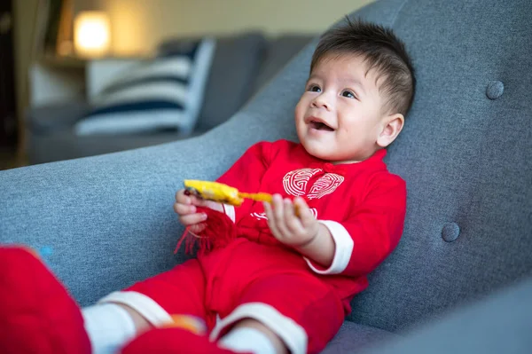 Baby Boy Holding Chinese Knot Good Luck While Sitting Sofa — Stock Photo, Image