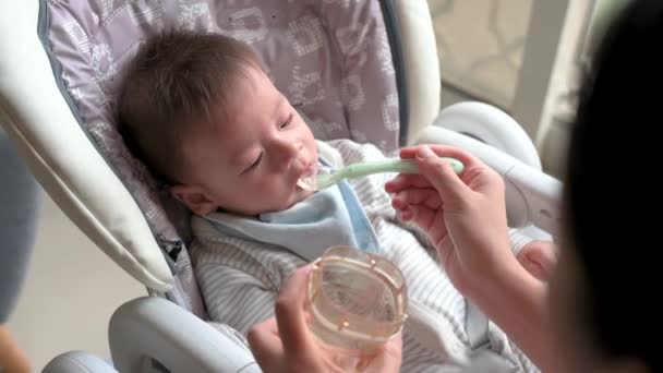 Mãe Alimentando Seu Bebê Menino Água Com Uma Colher Uma — Vídeo de Stock