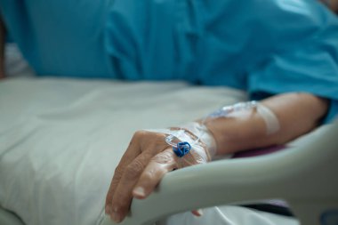 Yaşlı bir kadına serum fizyolojik tedavisi uyguluyor.