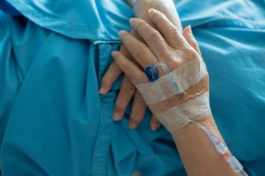 Yaşlı bir kadına serum fizyolojik tedavisi uyguluyor.