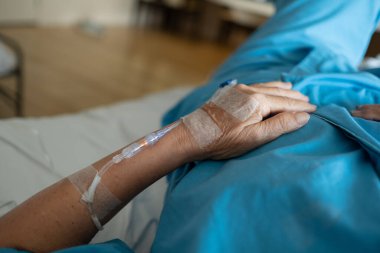 Yaşlı bir kadına serum fizyolojik tedavisi uyguluyor.