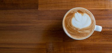 Tahta masada sıcak latte sanat kahvesi, rahatla Tim.