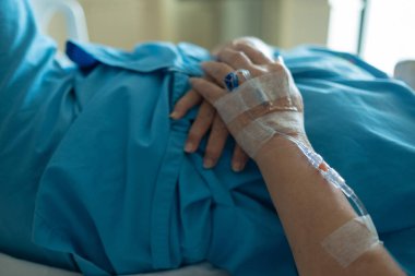 Yaşlı bir kadına serum fizyolojik tedavisi uyguluyor.