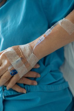 Yaşlı bir kadına serum fizyolojik tedavisi uyguluyor.