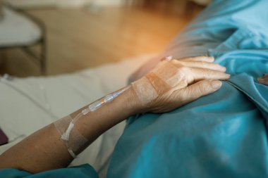 Yaşlı bir kadına serum fizyolojik tedavisi uyguluyor.