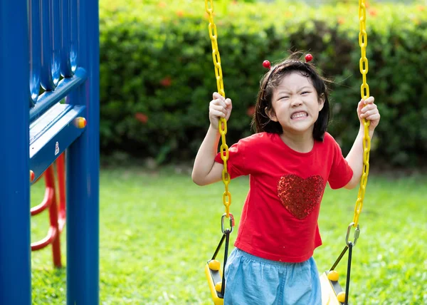 Çinli çocuklar salıncak oynuyor, çocuklar oyun parkında eğleniyor, mutlu kız