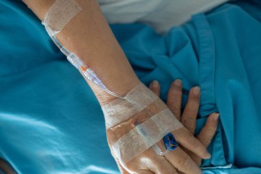 Yaşlı bir kadına serum fizyolojik tedavisi uyguluyor.