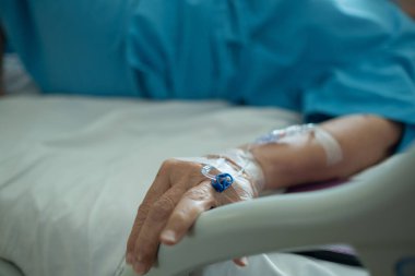 Yaşlı bir kadına serum fizyolojik tedavisi uyguluyor.