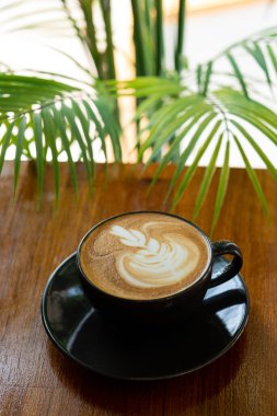 Tahta masada sıcak latte sanat kahvesi, rahatla Tim.