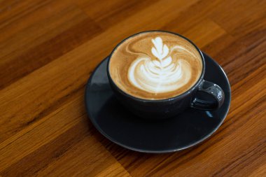 Tahta masada sıcak latte sanat kahvesi, rahatla Tim.