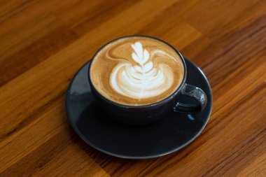 Tahta masada sıcak latte sanat kahvesi, rahatla Tim.