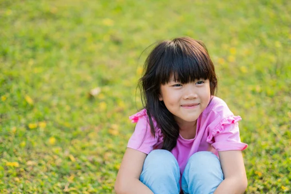 快乐的女孩坐在草地上 — 图库照片