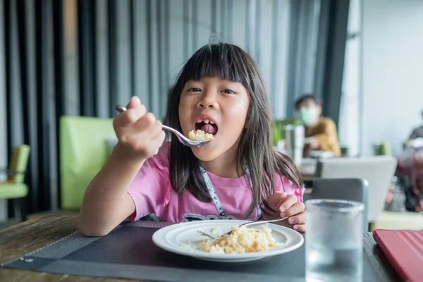 Çocuk yemek yiyor, eğleniyor, kahvaltı yapıyor.